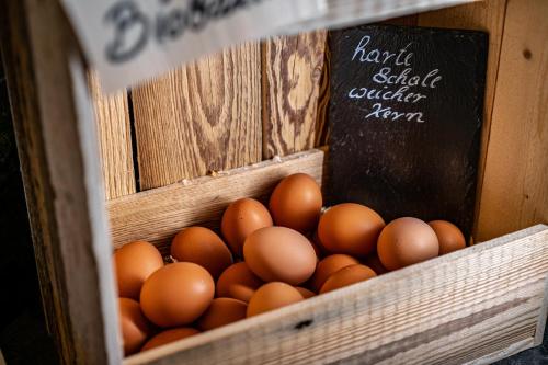 a crate of eggs in a box with a sign at Hotel Landhaus Tirolerherz in Sankt Ulrich am Pillersee