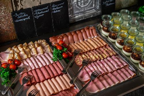 a table with different types of meats and other foods at Hotel Landhaus Tirolerherz in Sankt Ulrich am Pillersee