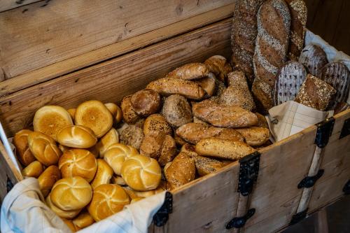 a wooden box filled with lots of different types of bread at Hotel Landhaus Tirolerherz in Sankt Ulrich am Pillersee