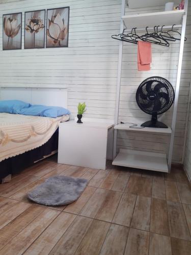 1 dormitorio con 1 cama y escritorio con ventilador en TownhouseFloripa II Praia do Moçambique-RioVermelho, en Florianópolis