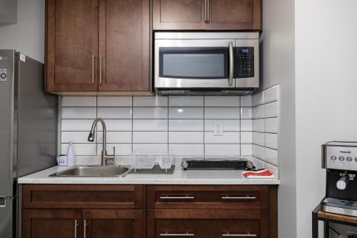 a kitchen with a sink and a microwave at The Jade Place in Airdrie