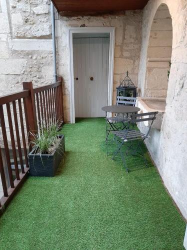 d'une terrasse avec une table et de la pelouse verte. dans l'établissement Le studio de la Clarté, à Périgueux