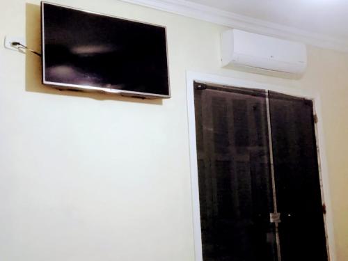 a flat screen tv hanging on a wall next to a window at Hospedaria Monumento in Sao Paulo