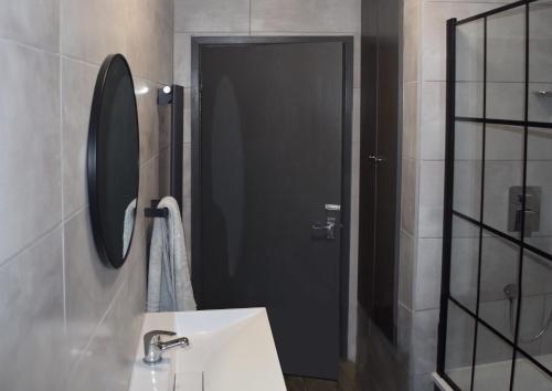 baño con lavabo y puerta negra en Forest Gate Haven, en Londres