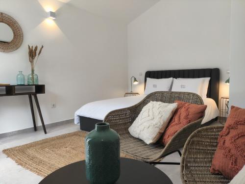 a bedroom with a bed with a green vase on a table at Quinta do Alento in Sesimbra