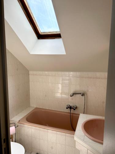 La salle de bains est pourvue d'une baignoire et d'une lucarne. dans l'établissement Gîte des halles : 4-6 pers. Maison de bourg., à Saint-Pierre-des-Nids