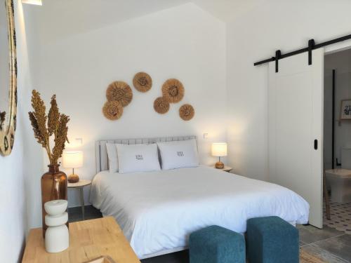 1 dormitorio con 1 cama blanca y 2 sillas azules en Quinta do Alento, en Sesimbra