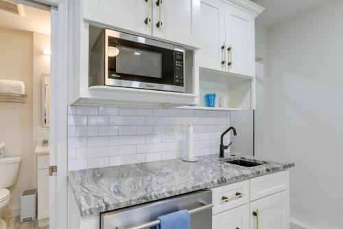 a white kitchen with a sink and a microwave at Cozy St Petersburg Studio Rental 1 Mi to Downtown in St Petersburg