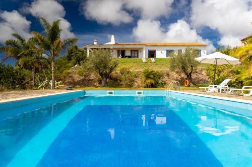 a villa with a swimming pool in front of a house at Monte Cerro da Vigia by Vacationy in Zambujeira do Mar