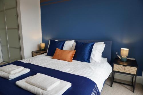 a blue bedroom with a bed with towels on it at Your Perfect Business Suite, 2 beds 2 bathrooms Apartment, Free Parking, Monthly Stays, Business, Contractors in Hemel Hempstead