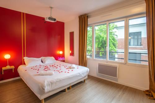 - une chambre avec un grand lit aux murs rouges dans l'établissement Spa & Détente - Cinéma - Parking - Gare, à Amiens