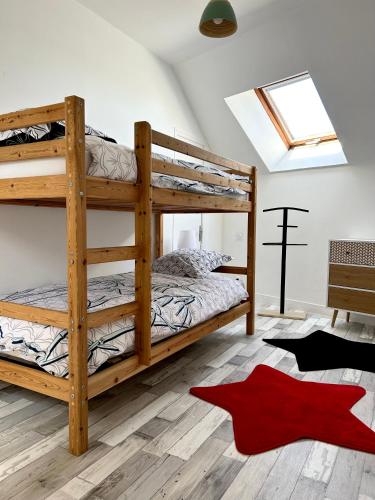 - une chambre avec 2 lits superposés et un tapis rouge dans l'établissement Gîte des halles : 4-6 pers. Maison de bourg., à Saint-Pierre-des-Nids