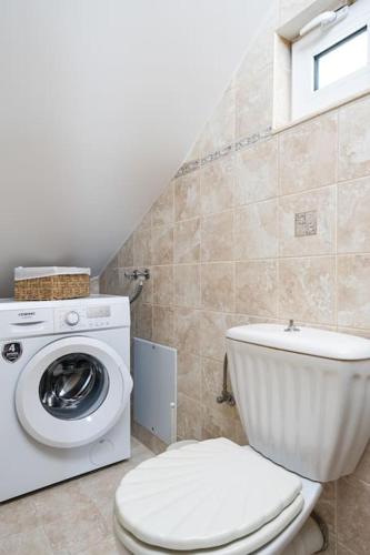 a bathroom with a toilet and a washing machine at Remvi house. Sea and mountains view. in Goúdhouros