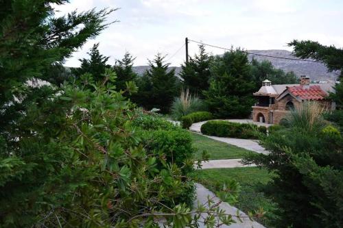 a garden with a pathway leading to a house at Remvi house. Sea and mountains view. in Goúdhouros