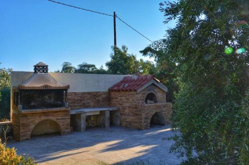 a small brick building with a bench in front of it at Remvi house. Sea and mountains view. in Goúdhouros