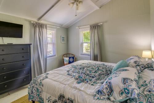 a bedroom with a bed and a dresser and windows at Oak Island Vacation Rental - 2 Blocks to Beach! in Oak Island