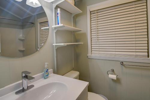 a bathroom with a sink and a toilet and a mirror at Oak Island Vacation Rental - 2 Blocks to Beach! in Oak Island