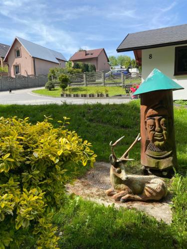 a statue of a deer sitting next to a bird feeder at Agroturystyka ‚U Misia’ in Krzywopłoty