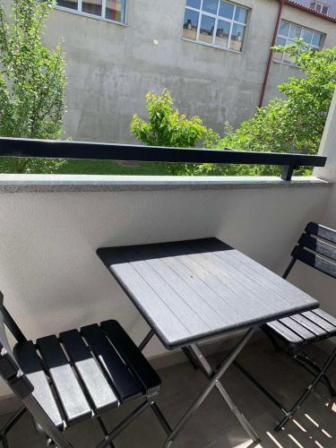 balcón con mesa de picnic y 2 sillas en STAN U CENTRU PRIJEDORA IZDAVANJE en Prijedor