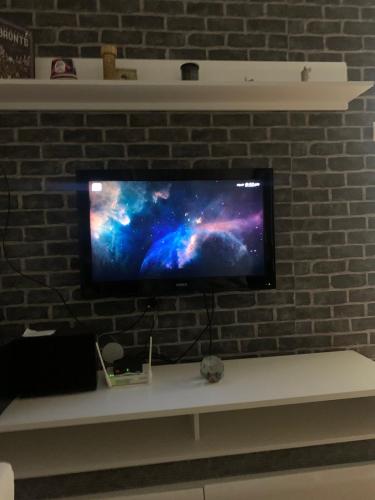 TV de pantalla plana colgada en una pared de ladrillo en STAN U CENTRU PRIJEDORA IZDAVANJE en Prijedor
