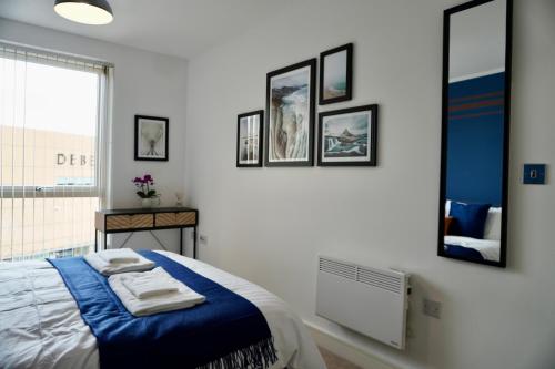 a bedroom with a bed with a blue blanket at Your Perfect Business Suite, 2 beds 2 bathrooms Apartment, Free Parking, Monthly Stays, Business, Contractors in Hemel Hempstead