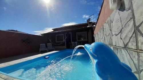 a dolphin water fountain in a swimming pool at Meu lugar de Descanso in Cabo Frio
