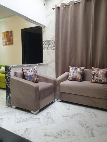 a living room with two chairs and a television at White House in Azrou