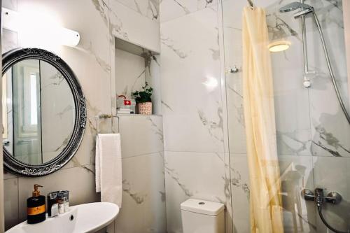 a bathroom with a shower and a sink and a mirror at Domus Vita Heraklio in Néa Alikarnassós