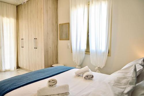 a bedroom with a bed with towels on it at Domus Vita Heraklio in Néa Alikarnassós