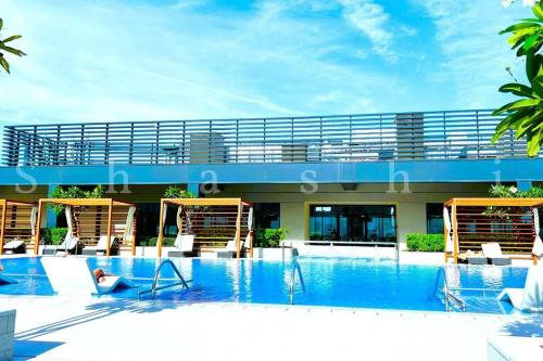 a large swimming pool with chairs and a building at The Shrashi Suites, Dubai Creek Harbour - Paradise on the Island with Dubai Skyline & Burj Khaleefa View in Dubai