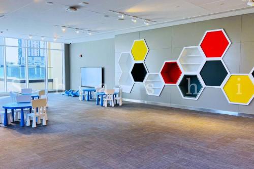a room with tables and chairs and a wall with colorful hexagons at The Shrashi Suites, Dubai Creek Harbour - Paradise on the Island with Dubai Skyline & Burj Khaleefa View in Dubai