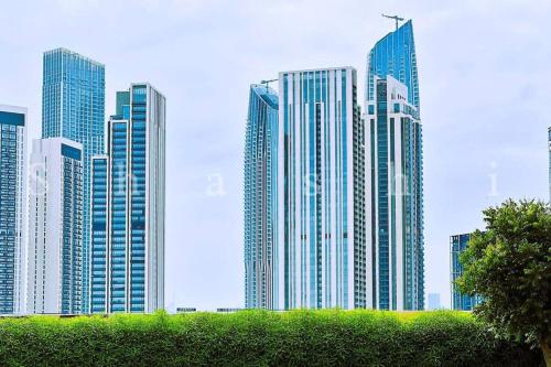 a group of tall buildings in a city at The Shrashi Suites, Dubai Creek Harbour - Paradise on the Island with Dubai Skyline & Burj Khaleefa View in Dubai