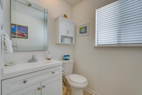 a bathroom with a toilet and a sink and a mirror at Cape San Blas Townhome with Beach Essentials! in Oak Grove