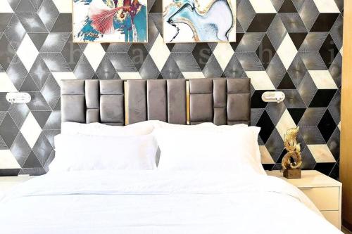 a bedroom with a white bed and a geometric wall at The Shrashi Suites, Dubai Creek Harbour - Paradise on the Island with Dubai Skyline & Burj Khaleefa View in Dubai