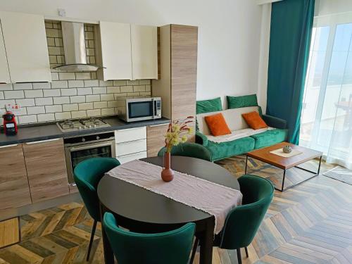 Il comprend une cuisine et un salon avec une table et un canapé. dans l'établissement Two bedroom loft apartment with outdoor area, served with lift, à Rabat