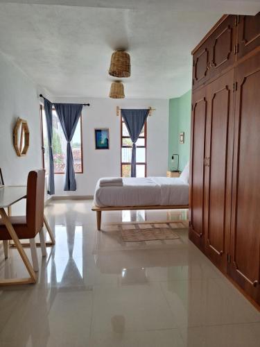 a bedroom with a bed and a table and a chair at Casa Mua in San Cristóbal de Las Casas