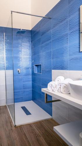 a blue bathroom with a shower and a sink at Tenuta Papola B&b in Brindisi