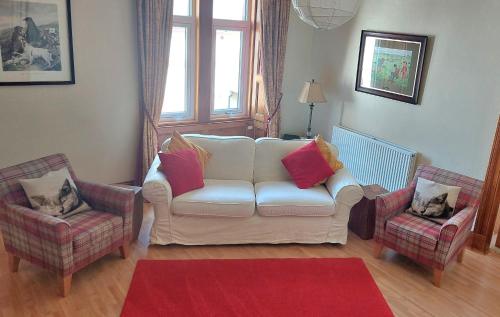 a living room with a white couch and two chairs at Upper Deck in Eyemouth