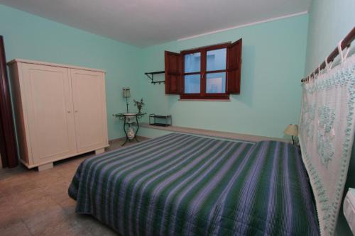 a bedroom with a bed and a window at B&B Nuraximannu in Santadi