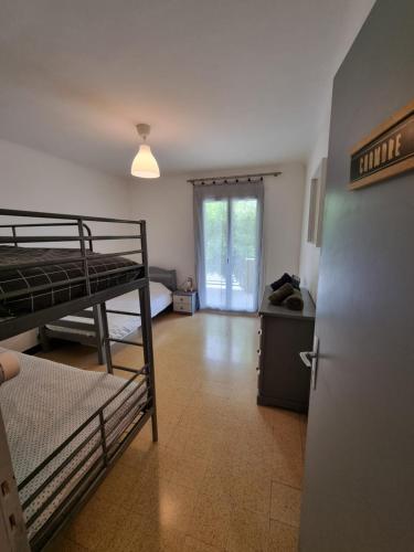 a room with two bunk beds and a hallway with a door at Maison avec extérieur dans un village provençal in Saint-Romain-en-Viennois