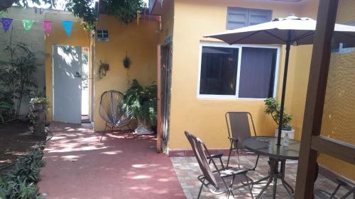 a patio with a table and chairs and an umbrella at Casa Atrapasueños in Valladolid