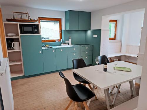 a kitchen with blue cabinets and a table and chairs at Siesta apartment Bled in Bled
