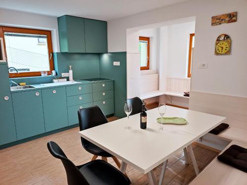 a kitchen with a white table and black chairs at Siesta apartment Bled in Bled