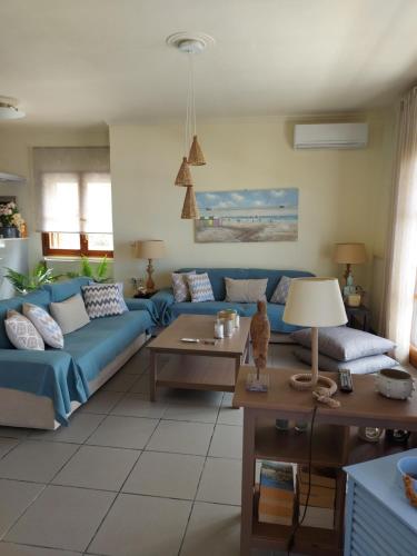 a living room with a blue couch and a table at Eolia apartment with panoramic Chania view in Chania Town