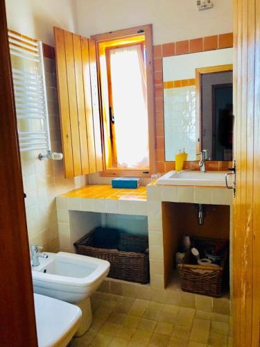 a bathroom with a sink and a toilet and a window at Monte Cerro da Vigia by Vacationy in Zambujeira do Mar