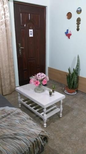 a table with flowers on it in front of a door at Saiyú Aeropuerto in Luque