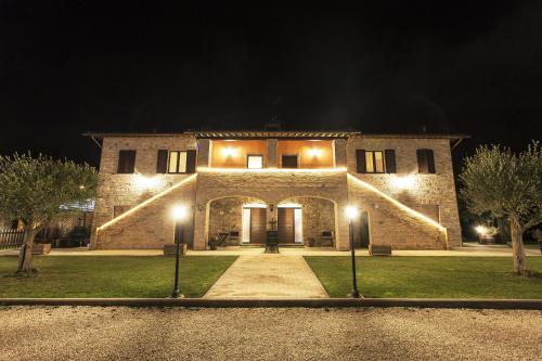 a large stone house at night with lights at Il Casale Della Fornace in Bastia Umbra