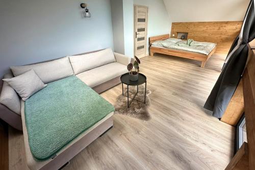 ein Wohnzimmer mit einem Sofa und einem Bett in der Unterkunft Welness chata pod Sitnom in Banská Štiavnica