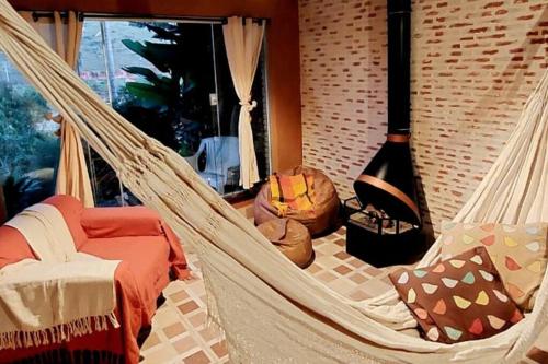 een kamer met een hangmat en een open haard bij MEU PEDACINHO DO CÉU um lugar para se desconectar in São Francisco Xavier