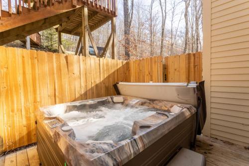 a hot tub in a backyard with a wooden fence at Heavens Door in Beech Mountain